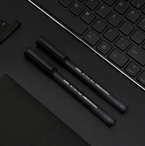 2 Pieces of Black Kacogreen Jumbo K6 Gel Pen Kept on black desk 