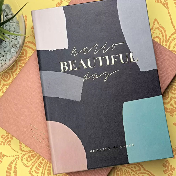 Undated Creative Convert Hello Beautiful Day Planner kept on table 