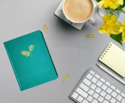 Creative Convert Sea Green Golden Leaf Journal kept on table with cup of tea